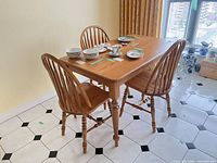 Table with three Windsor chairs, dishes on top not included