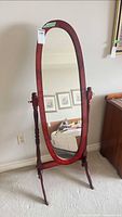 Front view of oval full-length cheval mirror on wooden stand