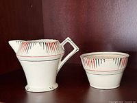 Cream pitcher jug and cup showing design and form