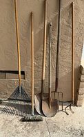 All six garden tools leaning against wall