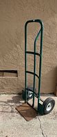 Full view of green hand truck dolly standing upright