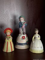 Front view of three porcelain bell figurines