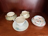 Four teacup and saucer sets displayed