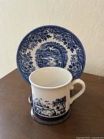 Cup and plate stood together showing front decoration