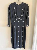 Full front view of gray polka dot dress on hanger