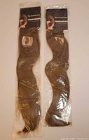 Two packaged hair extensions side by side showing brand card and full length