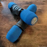 Pair of blue 3 lb Go Walking dumbbells with straps on wood surface