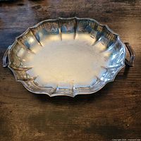 Top view of oval silver-plated bowl showing scalloped rim and handles