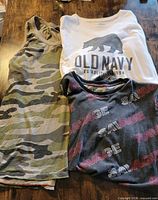 Three tops laid flat showing front graphics and patterns