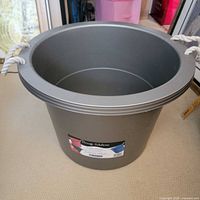 Full view of gray plastic bucket with rope handles