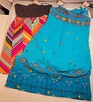 Both dresses laid flat showing full designs and colours