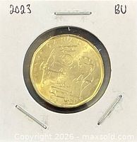 Full view of coin in holder displaying reverse with Elsie MacGill design