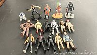 Top view of all 16 Star Wars figures spread out on surface