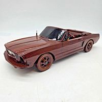 Angled front and side view of wooden 1965 Ford Mustang convertible model showing overall condition and details