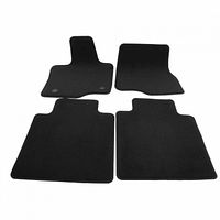 Four black carpeted floor mats laid out