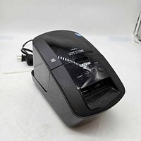 Front three-quarter view of Brother QL-720NW label printer showing buttons and hardwired power cord