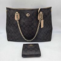 Front view of Coach signature canvas tote with chain straps and matching wallet