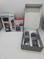 Lot overview showing boxed cold brew maker, boxed grinder, open gift box with two tumblers