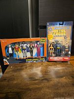 Both boxed figure sets on table: Batman Bendable Figures 5-pack and Justice League 3-pack