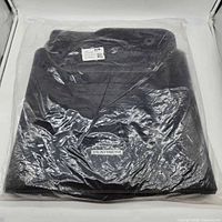 Sealed package containing stacked black carpet floor mats, Platinum logo visible