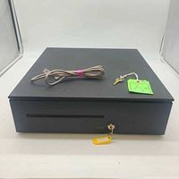 Closed APG cash drawer with cable and key on top