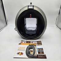 Front three-quarter view of coffee maker with leaflet