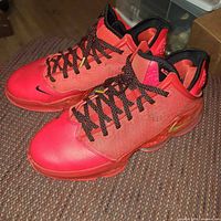 Side view of both shoes showing red uppers, black laces, cushioning pods