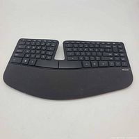 Front overview of a Microsoft Sculpt Ergonomic keyboard showing split layout and wrist rest