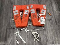 Both orange Mustang Survival adult D.O.T Standard life jackets showing reflective tape, straps and whistle