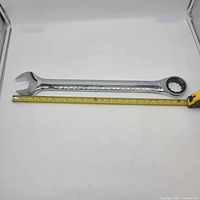 Full view of wrench beside tape measure showing length