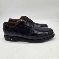 Side profile of both black leather Nike golf shoes