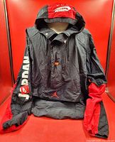 Front of black and red Nike Air Jordan Jumpman windbreaker showing sleeve lettering and pouch logo