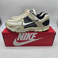 Side view of both shoes on Nike box