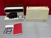 Overall view of sewing machine, case, manuals and cords