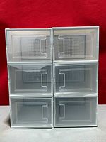front view of six clear plastic shoe organizer boxes stacked in two columns