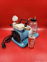 Overall view of aspirator pump showing pressure gauge, collection jar, carry handle and power cord
