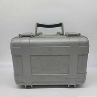 Front view of closed grey hard case showing handle, latches, exterior condition