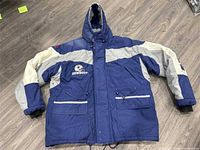 Front view of blue and grey Dallas Cowboys hooded winter coat showing logos, pockets, hood, and stripes