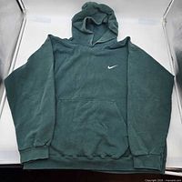 Front view of green Nike hoodie showing Swoosh logo and pocket