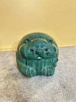 Front view of green and teal ceramic cat figurine