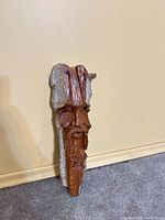 Front view showing carved bearded face and live-edge bark