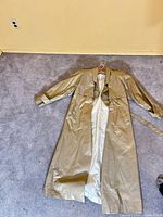 Full view of gold trench coat front with belt, showing material and length