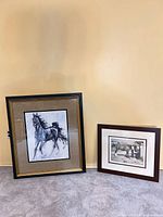 Both framed artworks side by side against wall