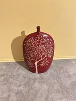 Front view of burgundy ceramic vase with beige tree motif