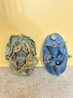 Front view of both plaques showing sizes, colors, forms, face detail and hanging holes