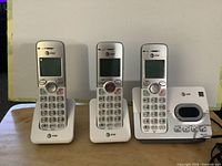Full set showing three handsets each on its cradle, base unit centered