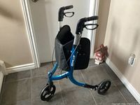 Side view of blue Goplus 3-wheel rollator walker showing frame, wheels, bag