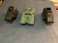 Three G.I. Joe tank hulls—green Toss n Cross center, two black Cobra H.I.S.S left and right—overview