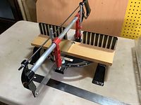 Mitre saw on base showing angle scale and spare blade in foreground