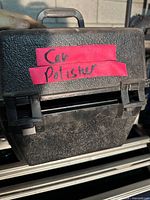 Black textured plastic carry case labeled for car polisher